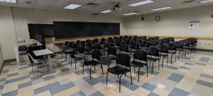 Journalism 239 before its renovation, featuring dated linoleum flooring and hard-to-reconfigure seating